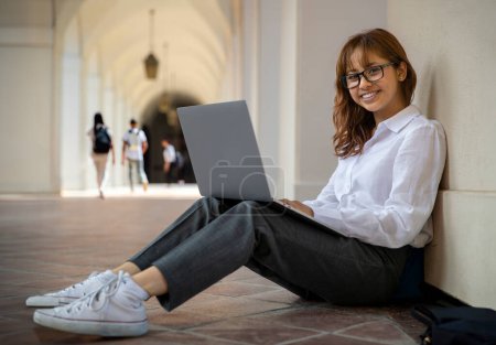 Foto de Retrato de una joven universitaria o estudiante de secundaria sonriente, alegre, estudiando, escribiendo, feliz de obtener una educación superior - Imagen libre de derechos