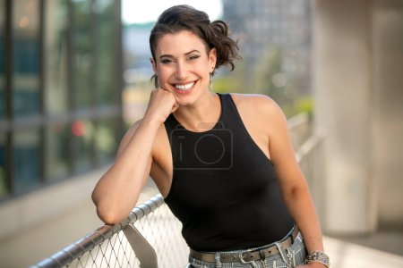 Photo for Friendly and charming portrait of a cheerful woman smiling in downtown modern urban area, alternative trendy lifestyle - Royalty Free Image