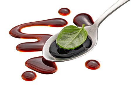 Balsamic sauce splash, salad vinegar in spoon with basil leaf isolated on white background