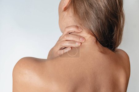 Téléchargez les photos : Femme nue avec douleur dans le cou et le dos sur fond blanc. Vue arrière
. - en image libre de droit