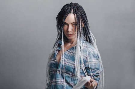 Foto de Portrait of woman with hairstyle with dreadlocks on gray background - Imagen libre de derechos