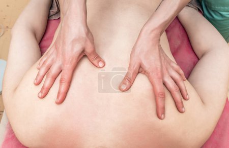 Photo for Back massage. Kneading muscles along spine. Therapist's hands. Prevention of diseases. - Royalty Free Image