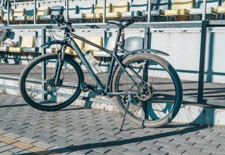 Foto de Bicicleta desbloqueada de color negro estacionado en una acera pavimentada en la ciudad de Rotterdam, Países Bajos. Blur calles de la ciudad fondo - Imagen libre de derechos