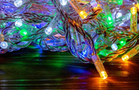 Téléchargez les photos : Guirlandes de nouvel an colorées avec des lampes LED sont laissées tomber de manière chaotique. Décor du Nouvel An, fond - en image libre de droit
