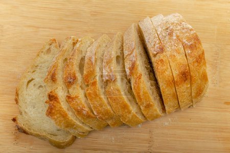 Téléchargez les photos : Top view of sliced fresh bread on wooden kitchen board. Concept of healthy eating. Close - en image libre de droit