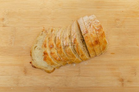 Téléchargez les photos : Vue du dessus du pain frais tranché sur une planche de cuisine en bois. Concept de saine alimentation - en image libre de droit