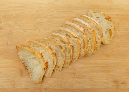 Téléchargez les photos : Vue du dessus du pain frais tranché sur une planche de cuisine en bois. Concept de saine alimentation - en image libre de droit