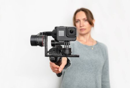 Modern portable video-photo stabilizer. Blur background woman. Vlog and video blog concept