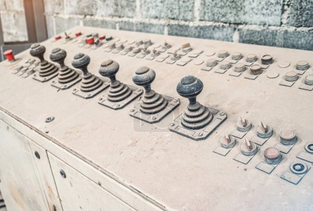 The old control unit is covered with dust. Joysticks to control equipment in the factory