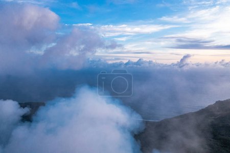 Smoke over volcano crater. Gray clouds ocean background. Vanuatu. Volcano accessible to tourists