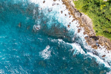 Foto de La espuma blanca de las olas golpea las rocas. Paisaje marino insuperable de color turquesa. Klungkung, Indonesia - Imagen libre de derechos