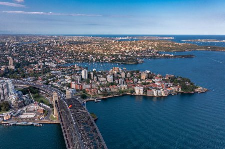 Téléchargez les photos : Vue aérienne le long du Sydney Arch Bridge à travers la mer de Tasman des bâtiments modernes de la ville. - en image libre de droit