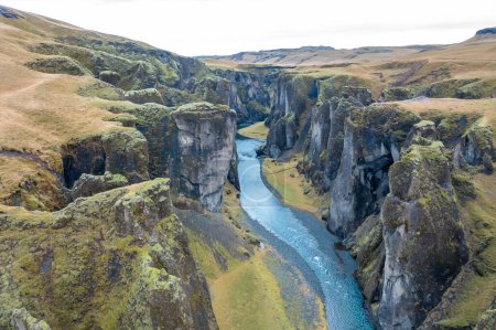 Wide estuary between hills in Iceland, winding blue river, stream. Tourist picturesque landscape