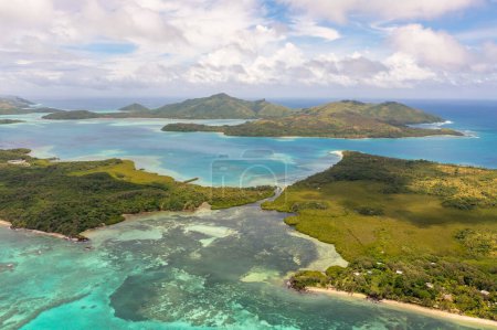 Drohnenblick auf grüne Meeresgewässer. Cumuluswolken über den Fidschi-Inseln. Urlaubs- und Reisekonzept.