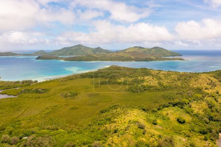 Türkisfarbenes Meerwasser unter den Wolken. Berge in der Ferne. Drohnenblick auf Fidschi-Inseln.