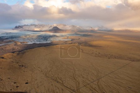 Nublado atardecer vista drone picos de montaña cubiertos de nieve. Valle volcánico abajo. Islandia Oriental.