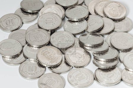 Ukrainian money, exchange coin, white coins denomination of 10 hryvnias in random order.  Macro