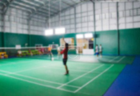 Athletes who are playing badminton in the badminton court, blurred image.