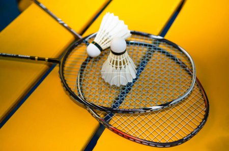 Téléchargez les photos : Raquettes de badminton et navettes de badminton crème blanche après avoir joué ou après des jeux sur le sol vert dans le terrain de badminton intérieur concept soft focus pour les amateurs de badminton du monde entier. - en image libre de droit