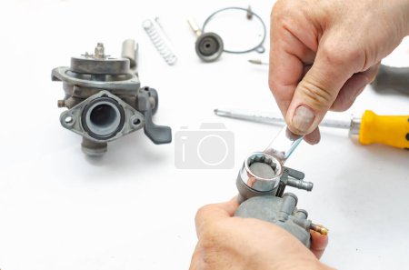 Téléchargez les photos : L'homme répare le carburateur de la voiture.. - en image libre de droit
