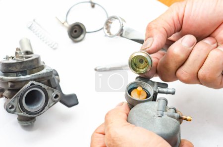 Téléchargez les photos : L'homme répare le carburateur de la voiture.. - en image libre de droit