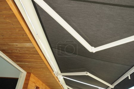 Photo for Close up on holders of automatic sliding canopy retractable roof system, patio awning for sunshade of a house. - Royalty Free Image