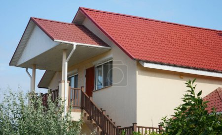 Metal house rooftop with entrance door and stairs