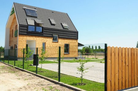 Passivhauskonzept. Modernes Haus mit Isolierung, Holzwänden, Dachfenster, Sonnenkollektoren, Solaranlage auf dem Dach zur Energieeinsparung und Energieeffizienz.
