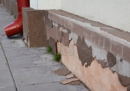 Photo for Bad house foundation waterproofing. House foundation repair caused by damp from rain gutter downspout pipe in problem area. House plinth foundation repair. - Royalty Free Image