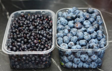 Blueberries and bilberries in boxes on the table as a concept of vitamin and antioxidants, super food and healthy lifestyle.