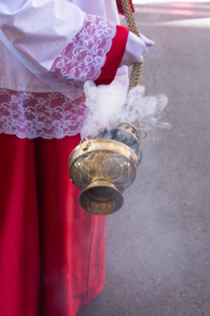 Photo for Madrid, Spain; April 2, 2023: Holy Week Procession on Palm Sunday. Close-up of an altar boy moving the incense burner. - Royalty Free Image