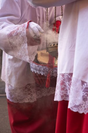 Photo for Madrid, Spain; April 2, 2023: Holy Week Procession on Palm Sunday. Close-up of altar boys lighting incense on a burner. - Royalty Free Image