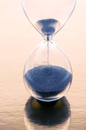 Téléchargez les photos : Hourglass on a golden background. time and minute measurement - en image libre de droit