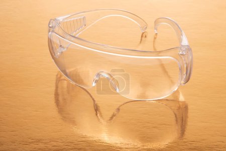 Photo for Protective work goggles on a golden background - Royalty Free Image