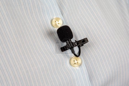Foto de Micrófono lavalier para grabación de voz en la camisa. tecnología de dispositivo de audio. micrófono pequeño con cable - Imagen libre de derechos