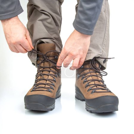 Foto de Botas de trekking para senderismo en las piernas de un turista sobre un fondo blanco. Equipamiento para viajes y senderismo - Imagen libre de derechos