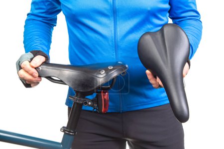 cyclist inspects, compares and selects a saddle for a bicycle.