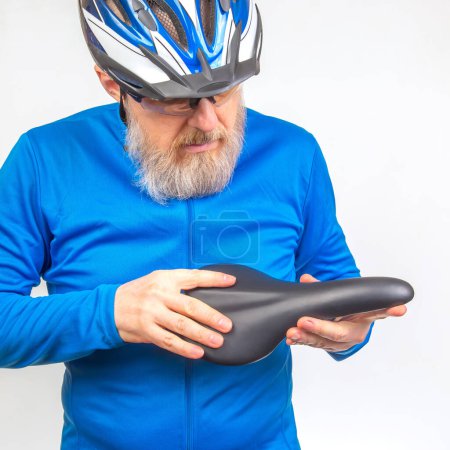 male cyclist checks the softness of his bicycle saddle. sports and transport equipment