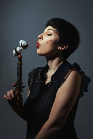 Photo for Portrait of vintage woman with retro gun and cotton - Royalty Free Image
