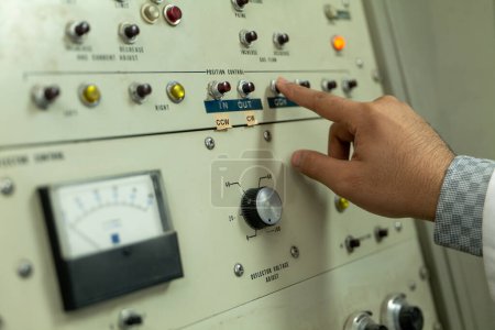 Control Panel of a Cyclotron Particle Accelerator. High quality photo the control panel of a cyclotron particle accelerator. The panel is filled with glowing buttons, dials, and gauges, and it is