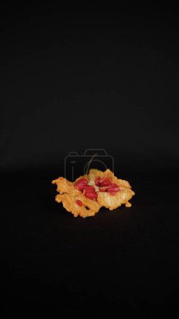 Téléchargez les photos : Focus sélectif de vue de face et portrait de demi coupé jaune amer gourd sur mûr et éclaté avec des graines rouges isolées sur fond de tissu noir - en image libre de droit