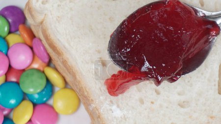 Téléchargez les photos : Cuillère de confiture de fruits dans du pain aux pépites de chocolat, très gros plan - en image libre de droit