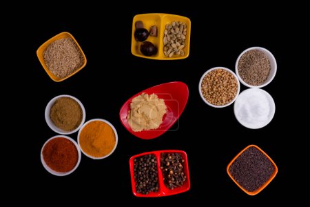 Photo for Two Set Of Three Round Bowls, Two Square Bowl, Tow Double Box Square Bowl And One Long Red Small Bowl Filled With Spices From The Kitchen Each Set And Bowl Has Different Location. Isolated On Black Background. Spices Like, Mustard Seeds, Coriander Se - Royalty Free Image