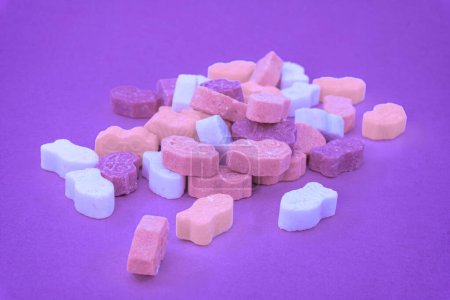 Foto de Dulces caramelos multicolores, aislados sobre fondo de color magenta - Imagen libre de derechos
