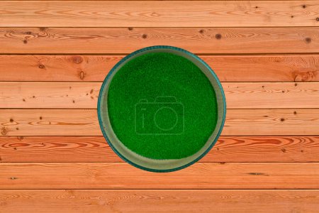 Téléchargez les photos : Couleur vert foncé sur la surface du bois, couleur Rangoli dans le bol - en image libre de droit