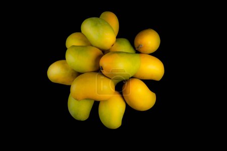 Foto de Un montón de mangos, aislado sobre fondo negro, espacio de copia - Imagen libre de derechos