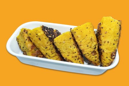 Foto de Close-Up Gujarati Handvo / Handwa trozos de pastel de verduras en tazón blanco aislado sobre fondo amarillo - Imagen libre de derechos