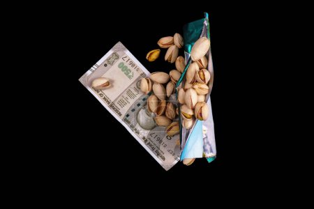 Photo for Pistachios with currency note on black background - Royalty Free Image