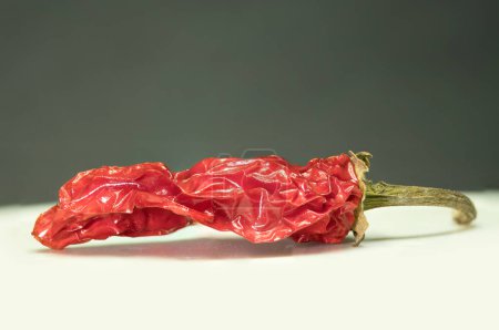 Spice of Life : A Close-up of a Vibrant, Aged Red Chili Pepper, Cette image présente un gros plan d'un seul piment rouge vieilli. Sa texture ridée et sa couleur rouge intense, révélant sa maturité