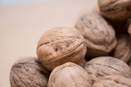 Organic Walnuts: A Close-Up of Nature's Intricate Design, Experience the beauty of nature's design with this close-up shot of organic walnuts. The central walnut, in sharp focus, reveals rich texture